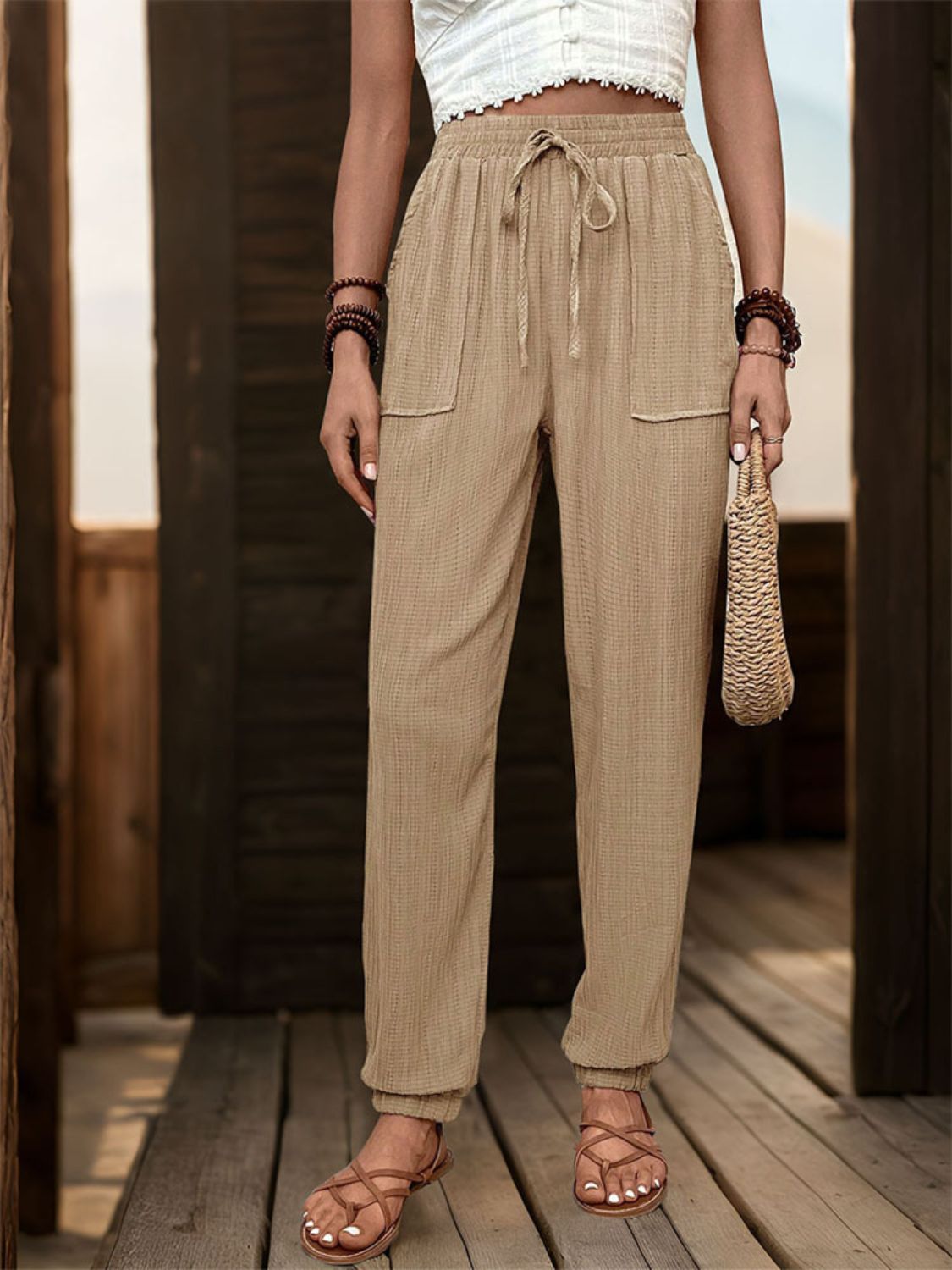 Textured high waist joggers with tie and pockets, opaque.