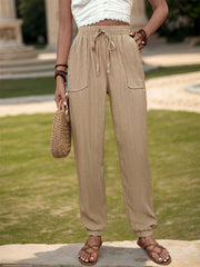 Textured high waist joggers with tie and pockets, opaque.