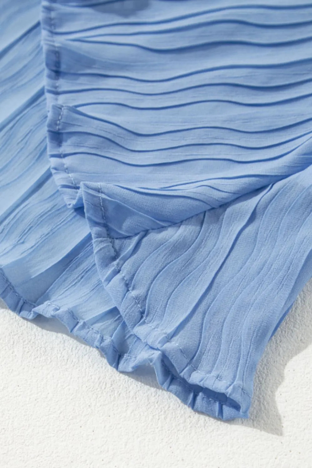 Textured pleated tied mock neck flowy tank top.