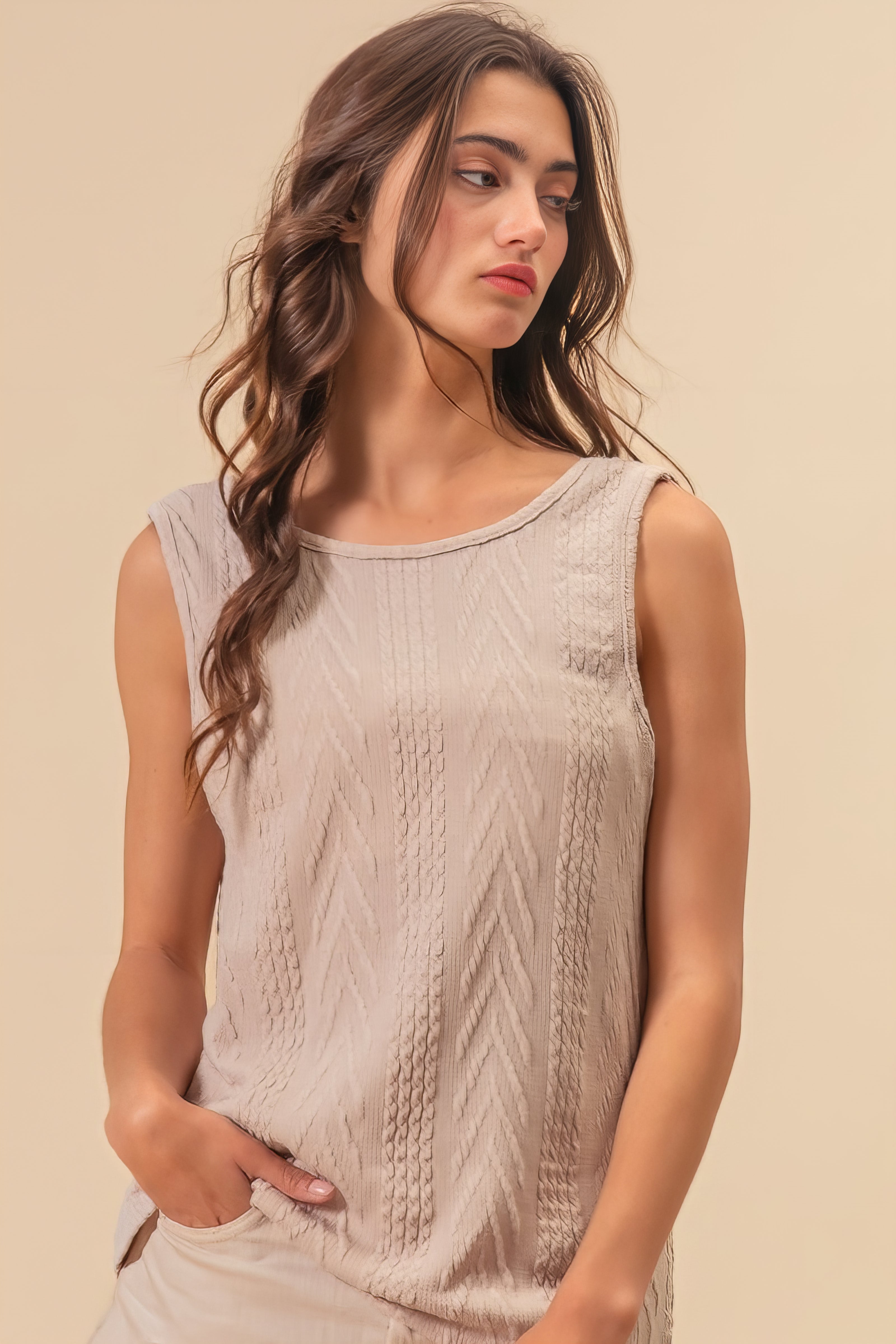 Textured sweater knit twist back sleeveless top with cable-knit design, slightly stretchy.