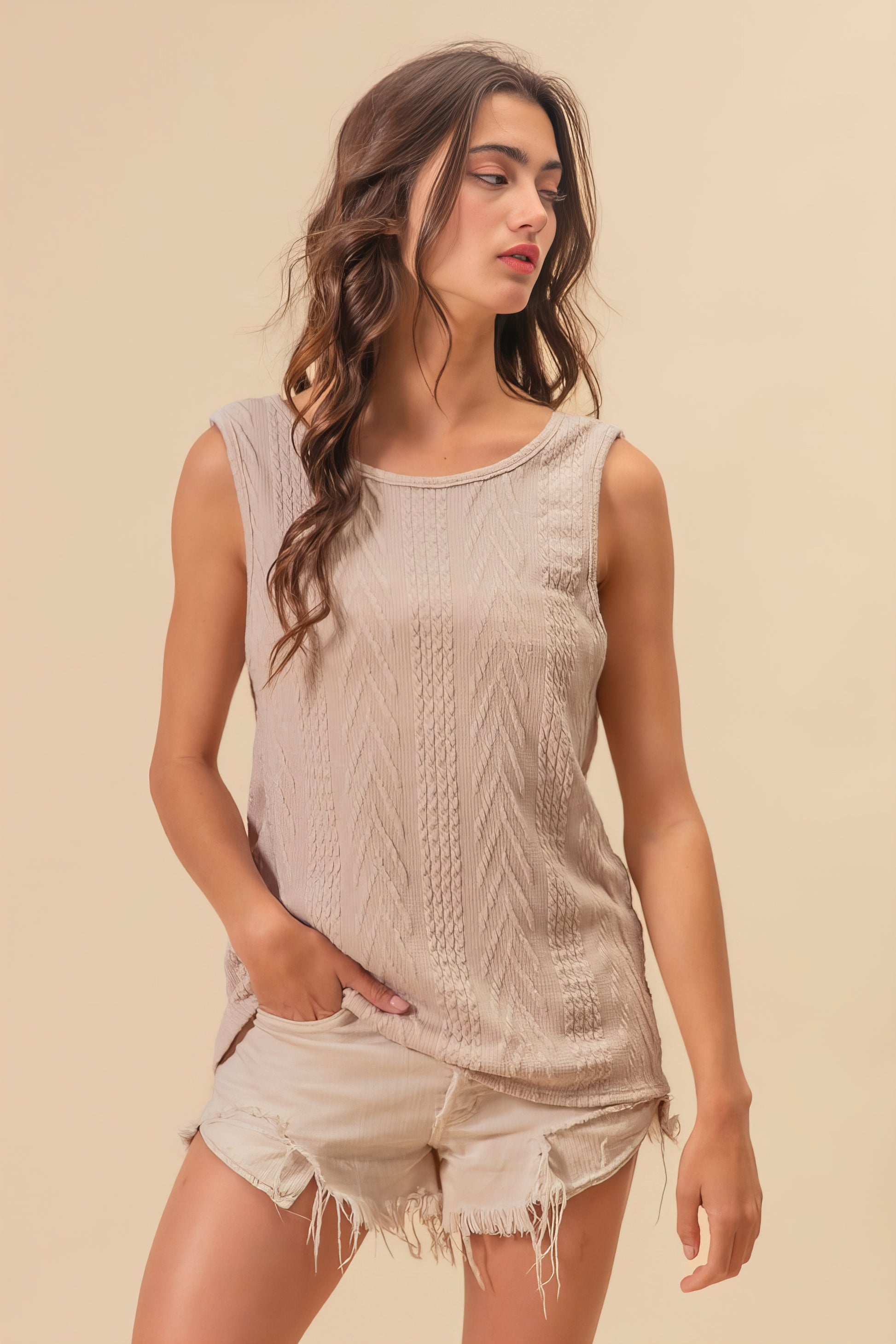 Textured sweater knit twist back sleeveless top with cable-knit design, slightly stretchy.