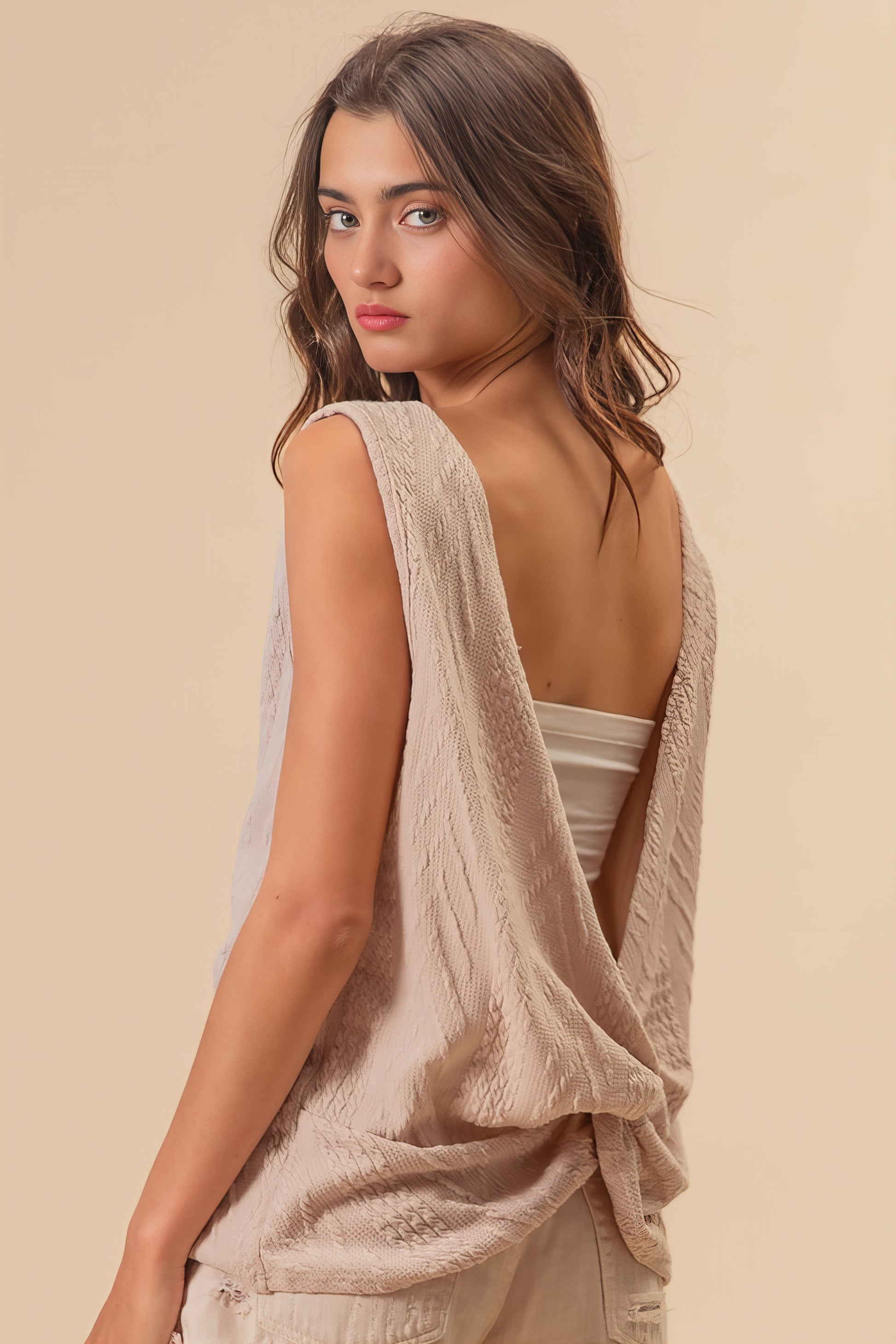 Textured sweater knit twist back sleeveless top with cable-knit design, slightly stretchy.