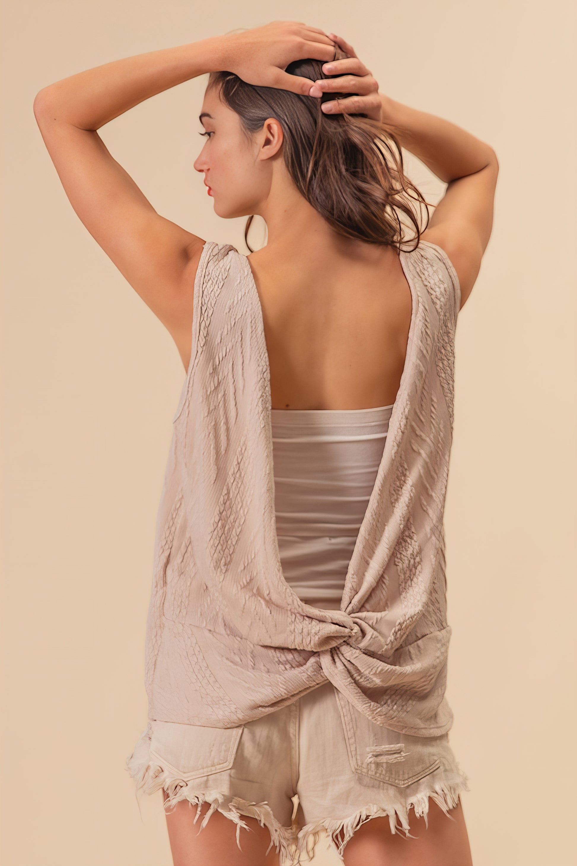 Textured sweater knit twist back sleeveless top with cable-knit design, slightly stretchy.