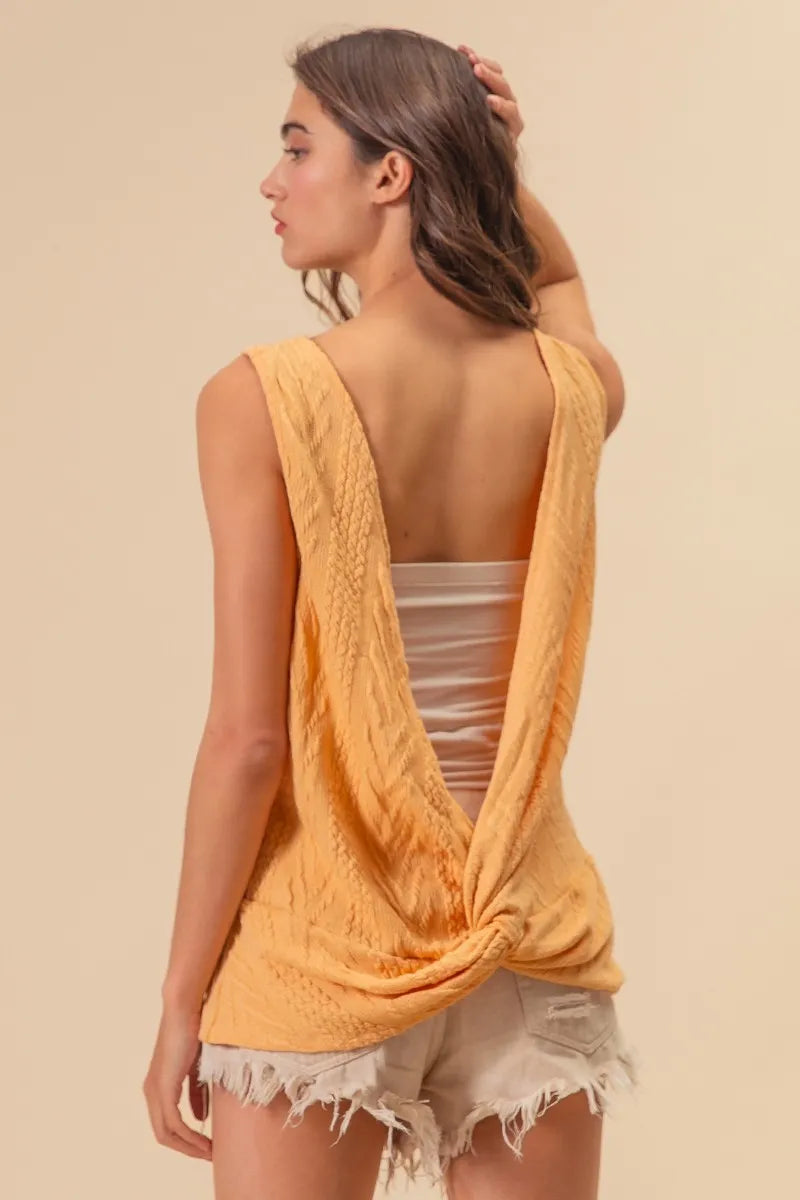Textured sweater knit twist back sleeveless top with cable-knit design, slightly stretchy.