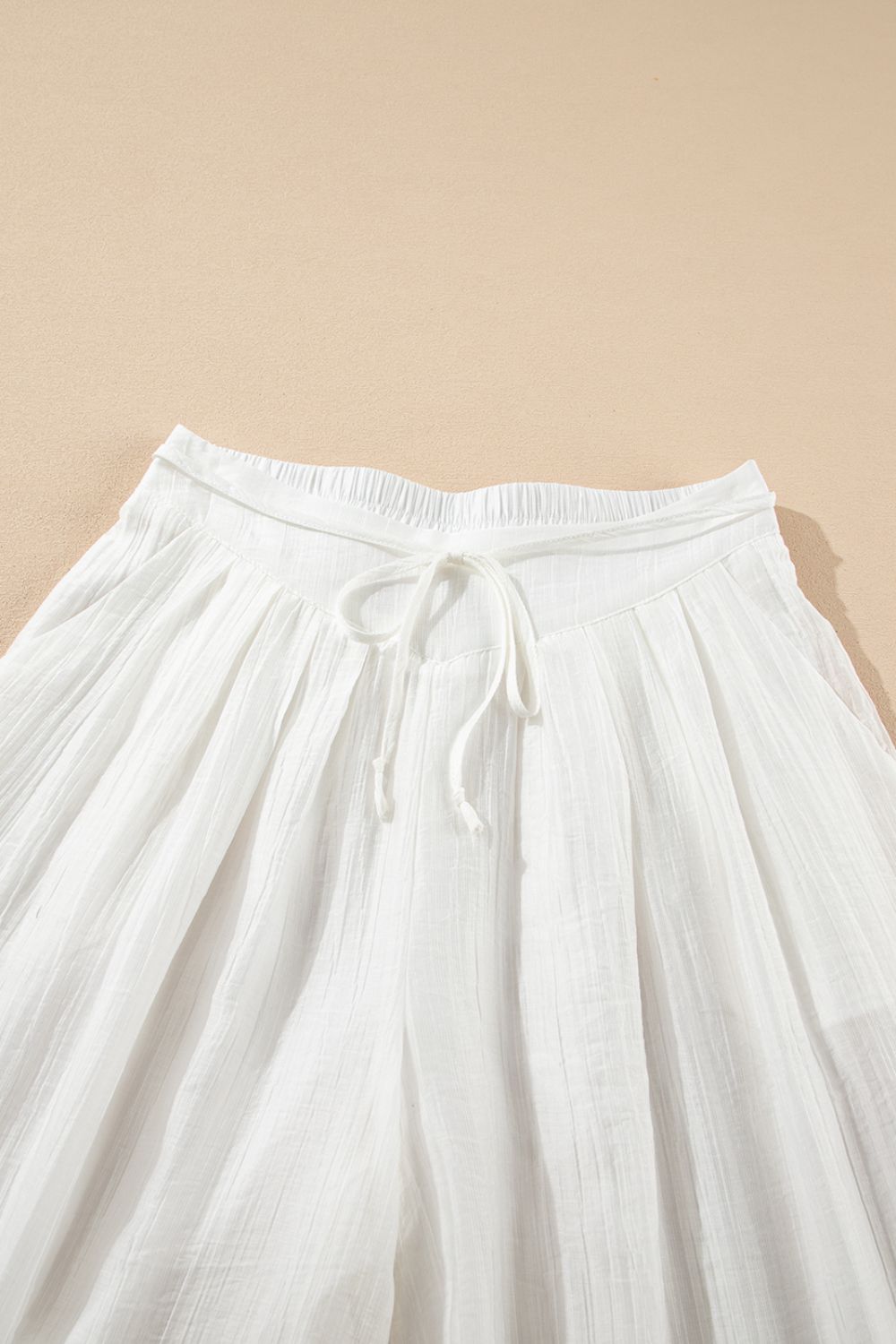 Tie waist pleated wide leg pants, opaque.