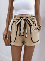 Distressed raw hem denim shorts with buttons and pockets.