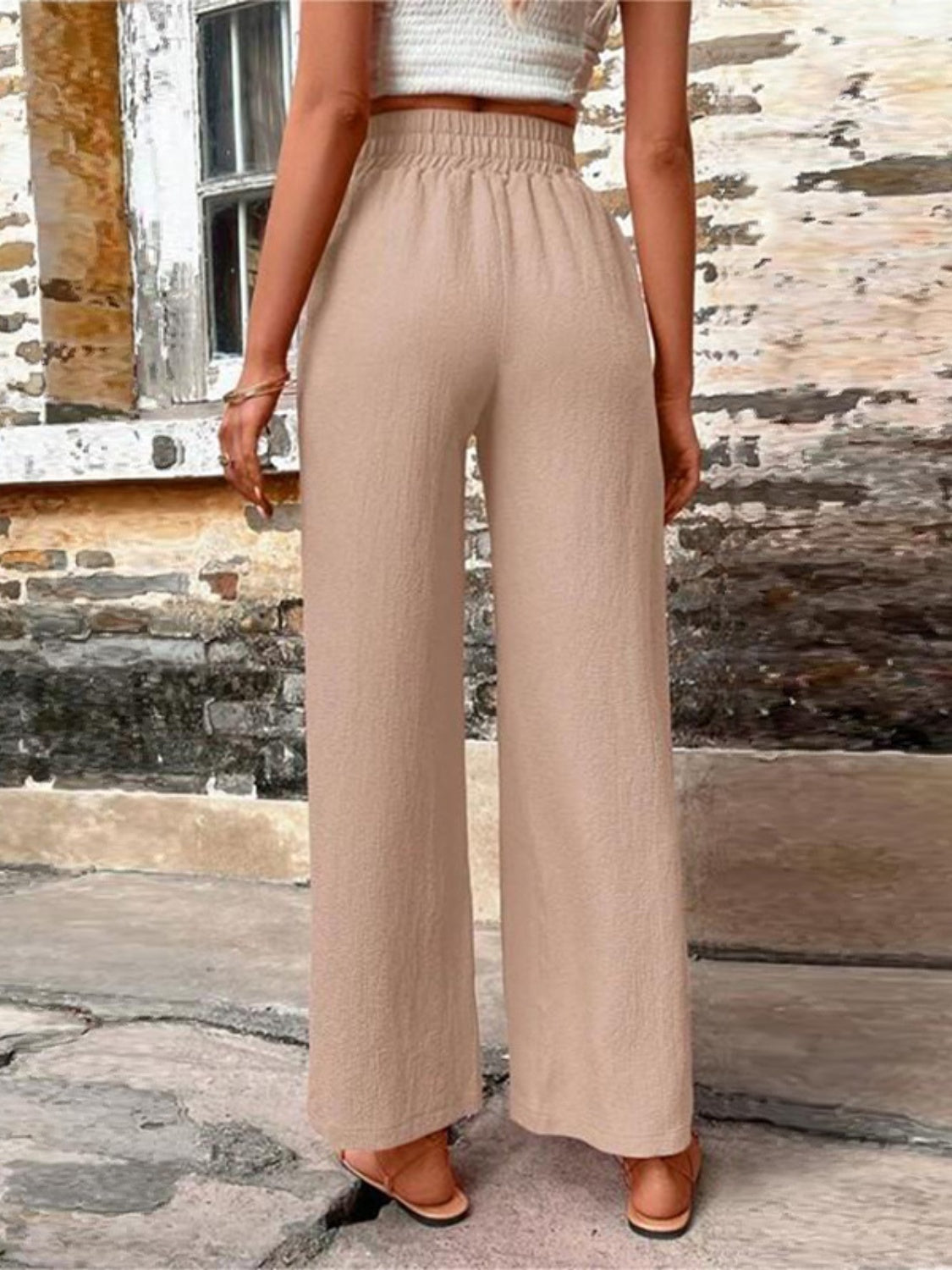 Tied high waist wide leg pants with pockets and decorative buttons, opaque.