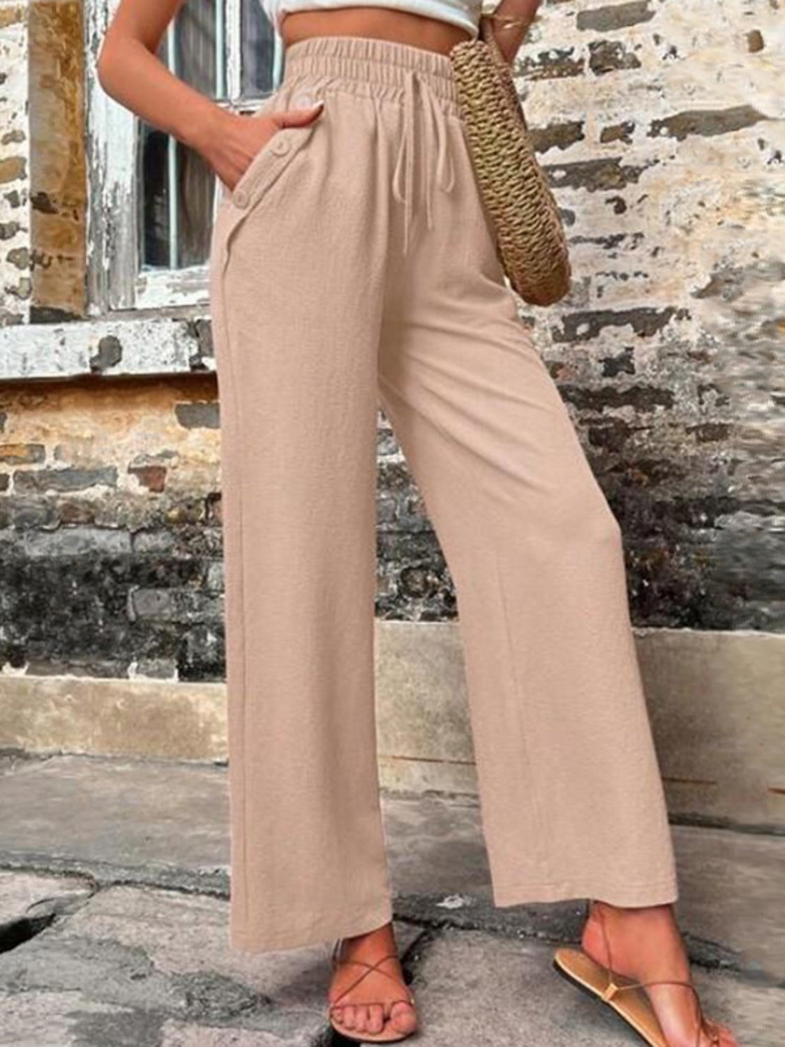 Tied high waist wide leg pants with pockets and decorative buttons, opaque.