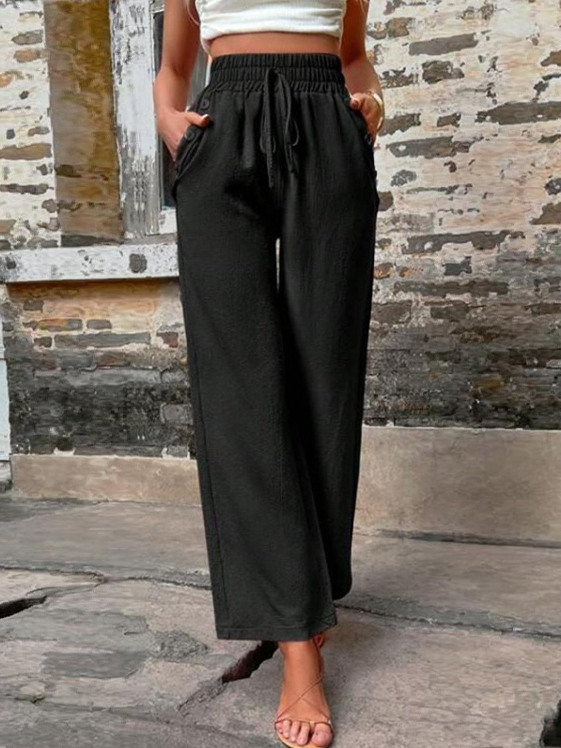 Tied high waist wide leg pants with pockets and decorative buttons, opaque.