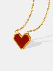 Titanium steel heart necklace with a polished gold-plated link chain and bold red heart pendant framed by a textured gold-tone border.