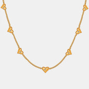 Gold-tone titanium steel zircon heart necklace featuring a delicate chain with multiple polished heart charms and sparkling zircon accents, including a central heart pendant.