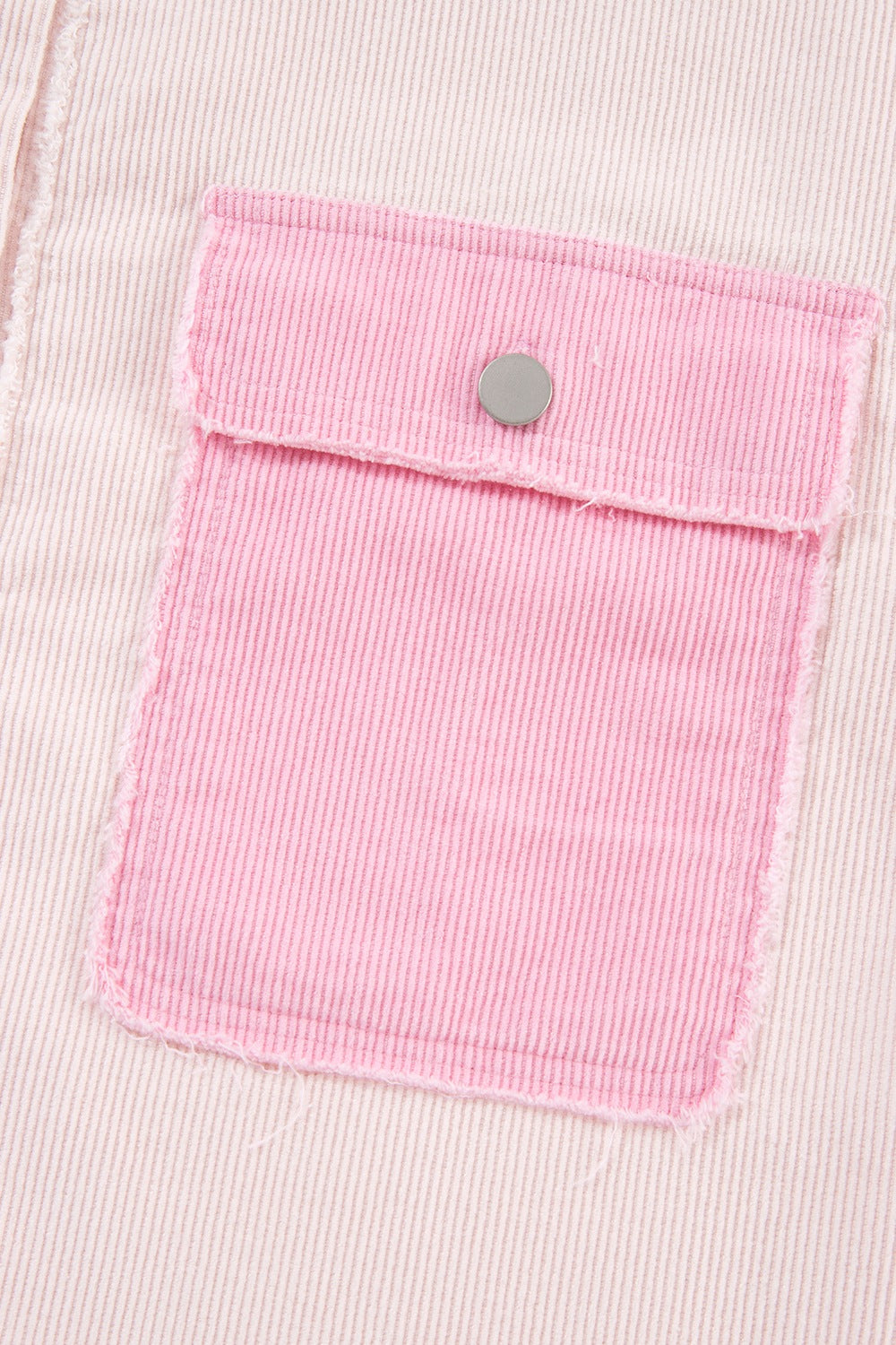 Two-tone exposed seam corduroy shacket with pockets, raw hem, and buttons.