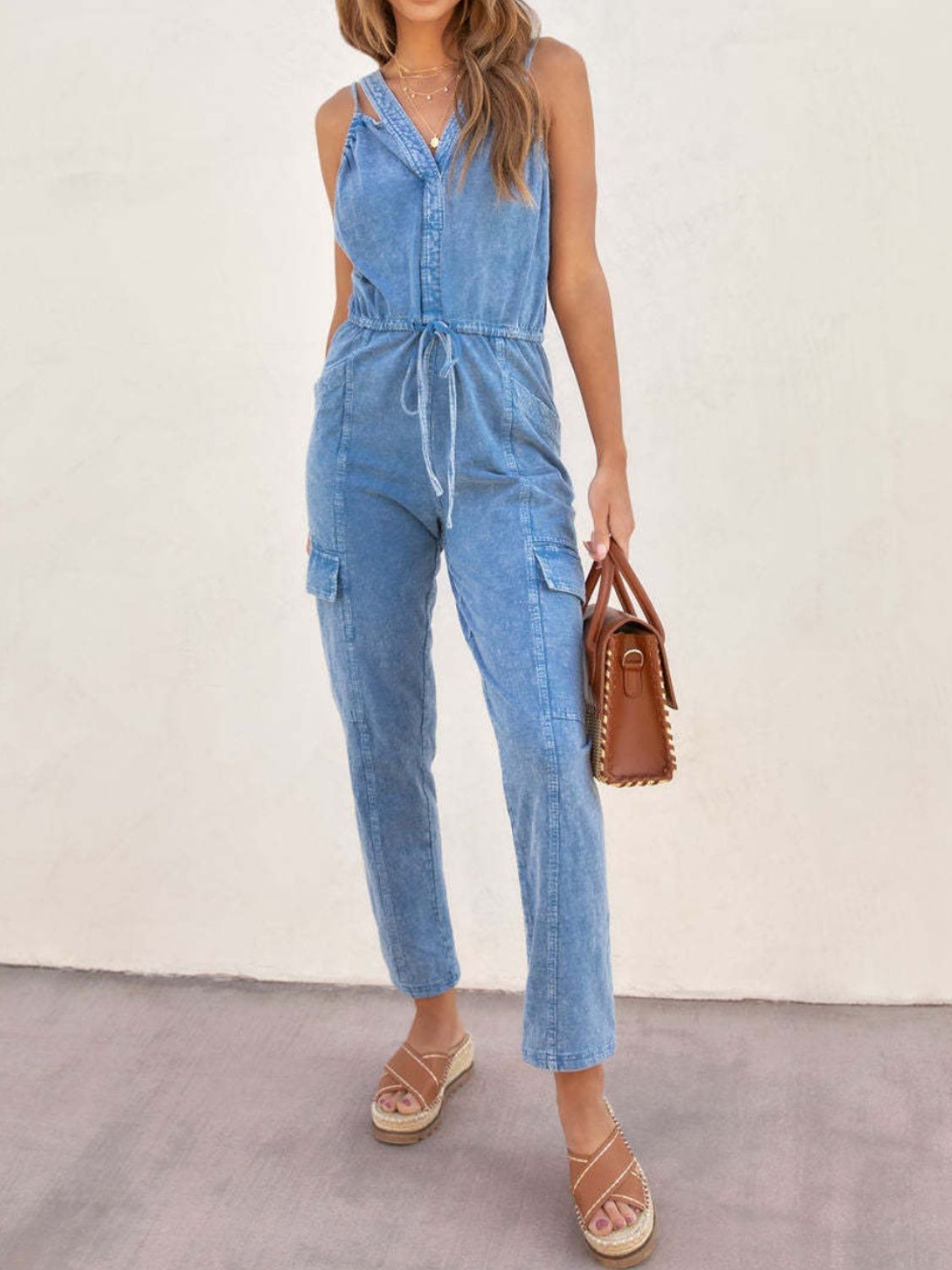 V-Neck Sleeveless Denim Jumpsuit with Pockets and Drawstring.