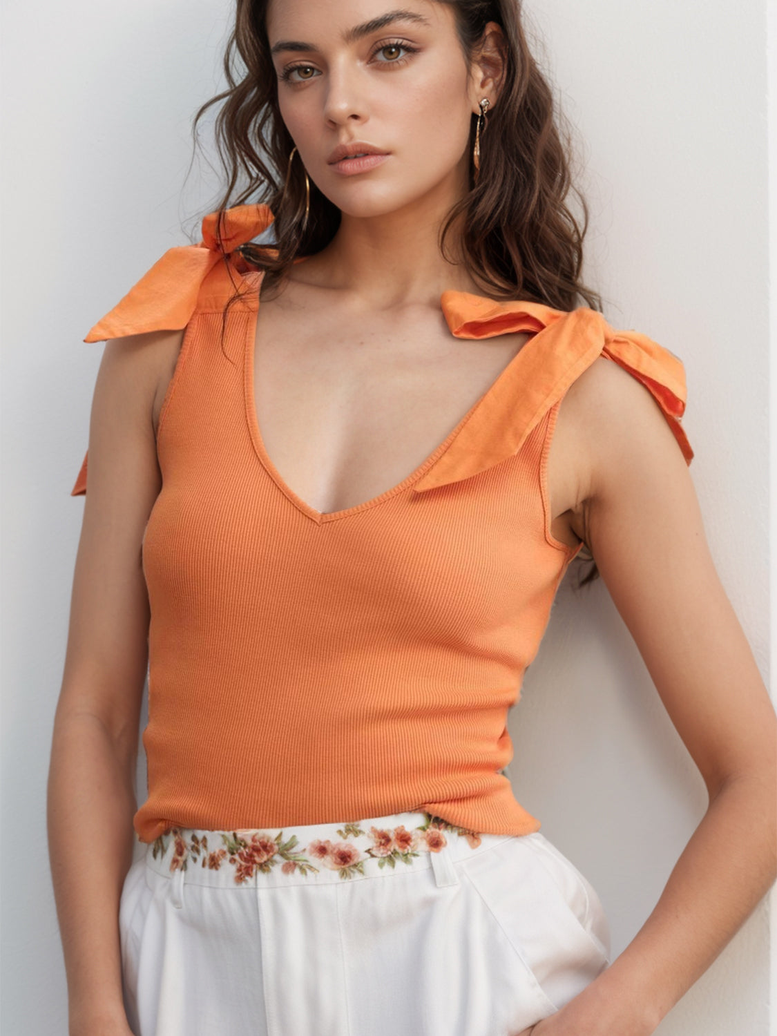 V-neck tie shoulder tank with bow, moderately stretchy.