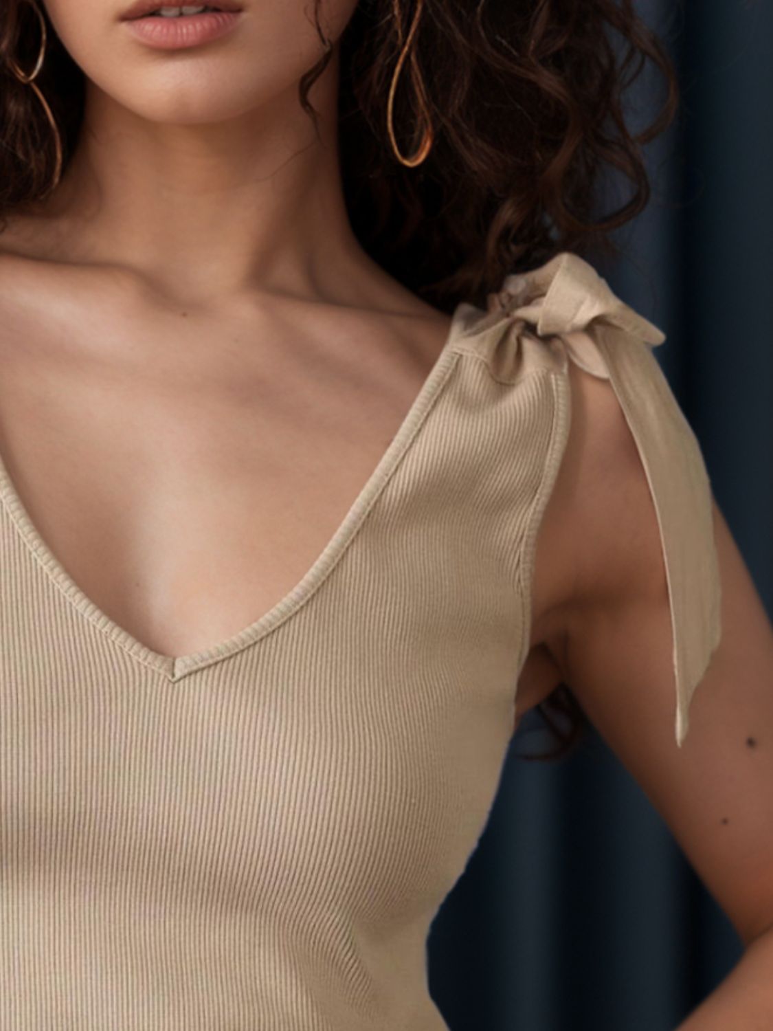 V-neck tie shoulder tank with bow, moderately stretchy.