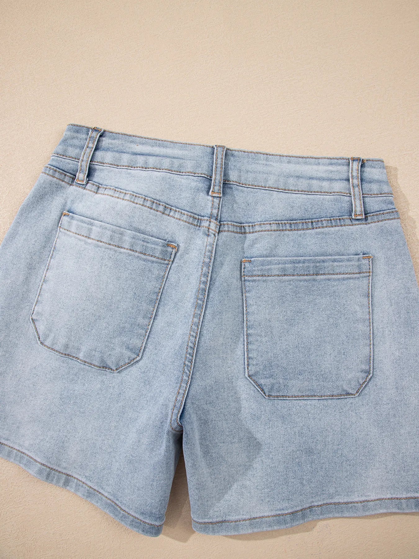 High-waist V-front Bermuda denim shorts with pockets.