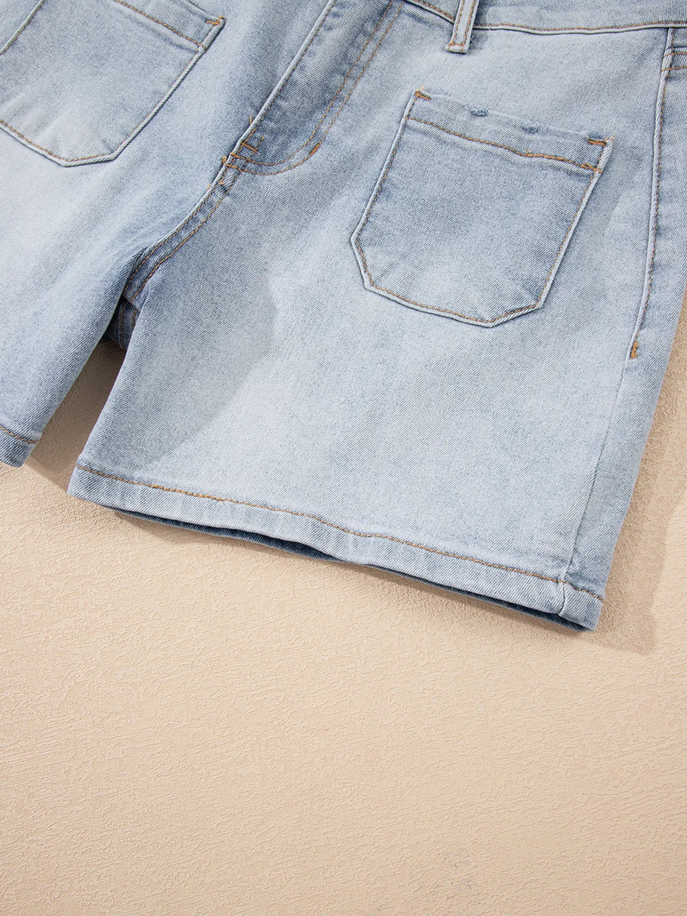 High-waist V-front Bermuda denim shorts with pockets.