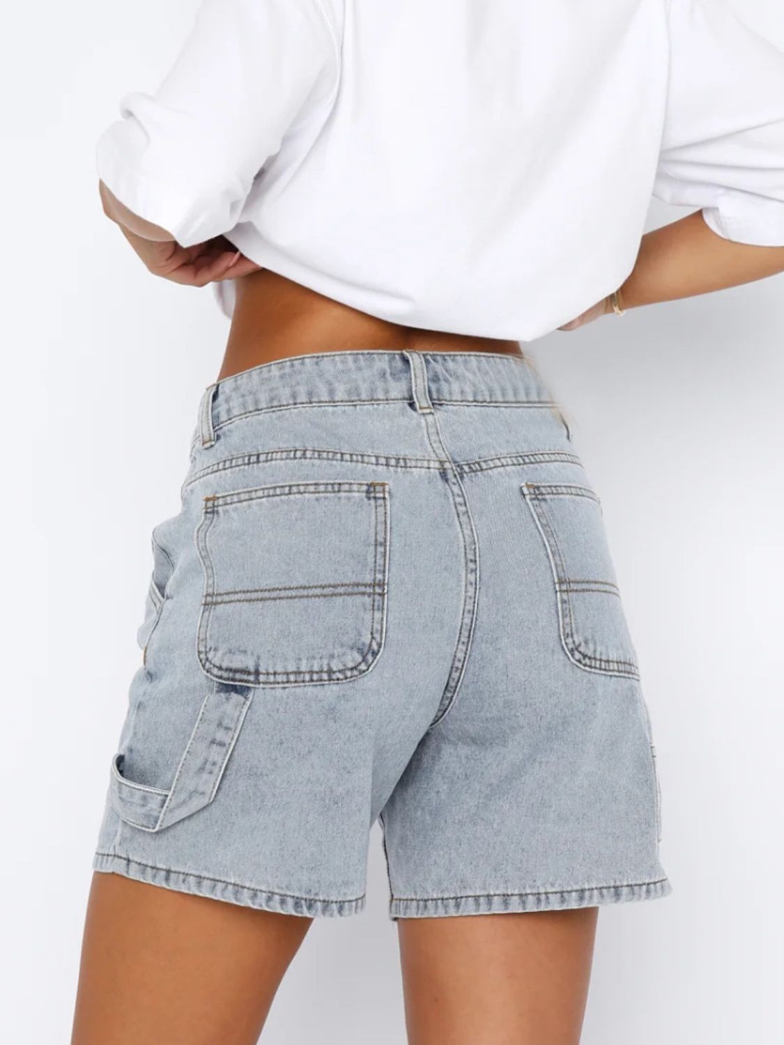 Distressed raw hem denim shorts with buttons and pockets.