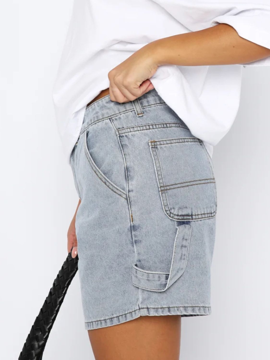 Distressed raw hem denim shorts with buttons and pockets.