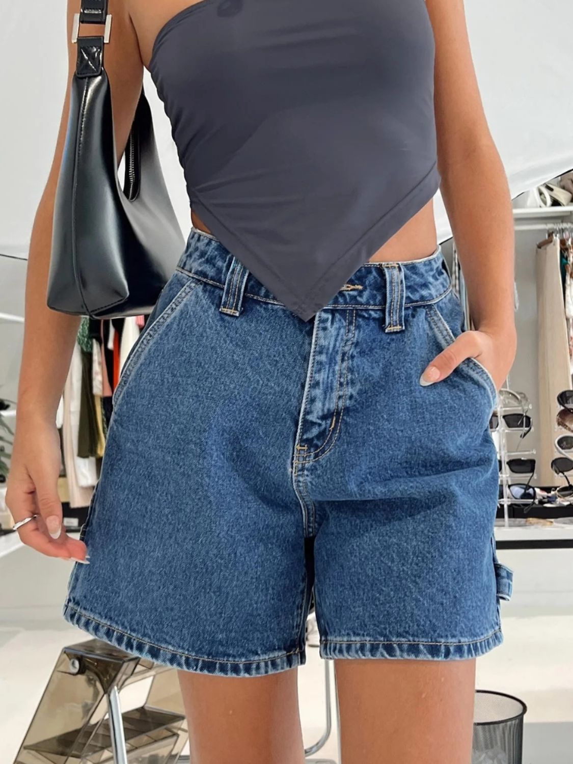 Distressed raw hem denim shorts with buttons and pockets.
