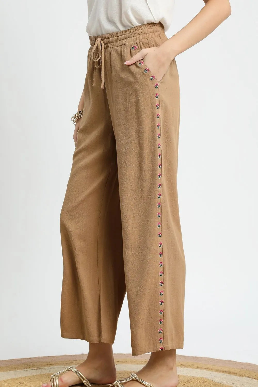 Wide leg drawstring pants with pockets and decorative trim.