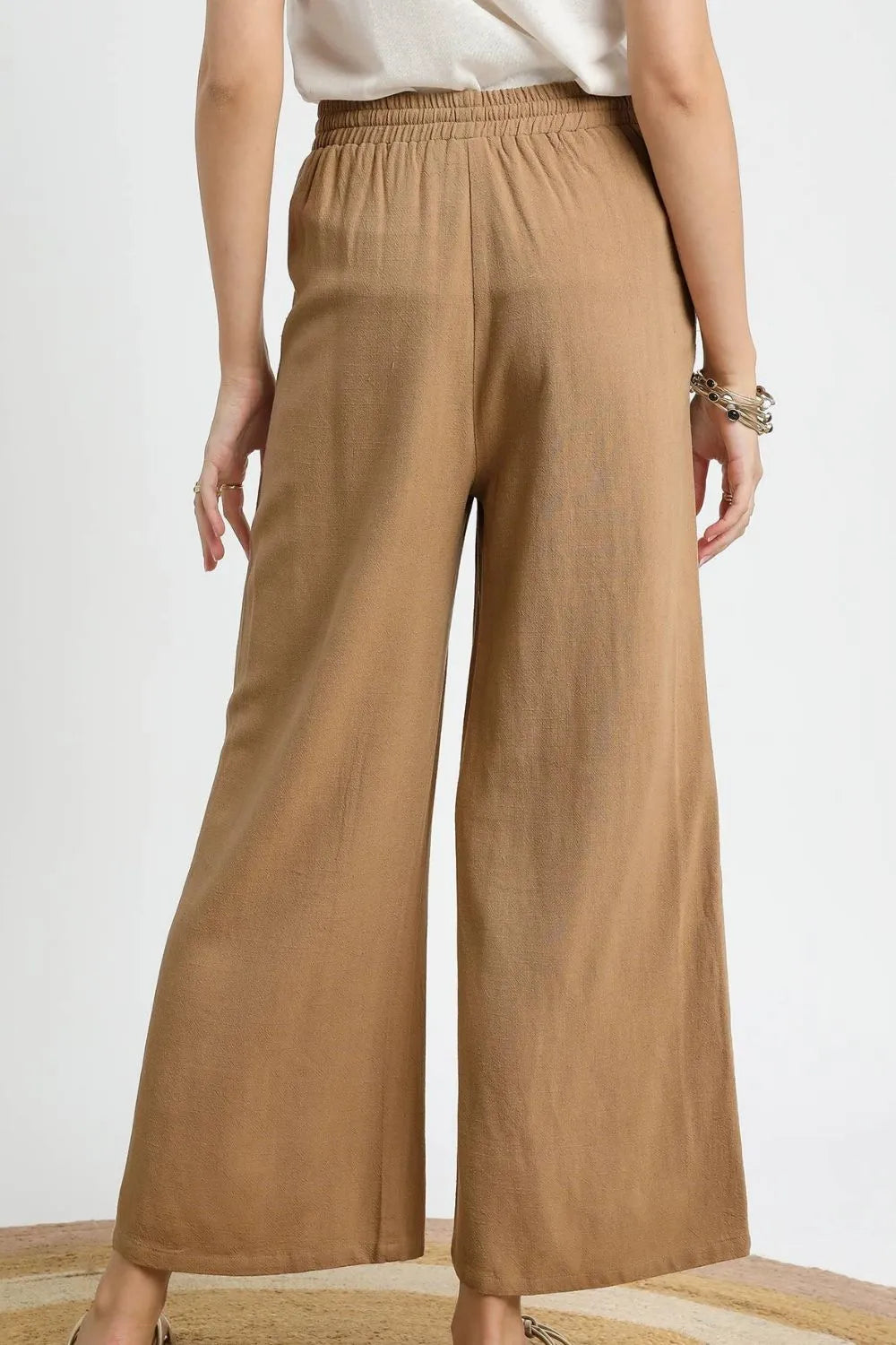 Wide leg drawstring pants with pockets and decorative trim.