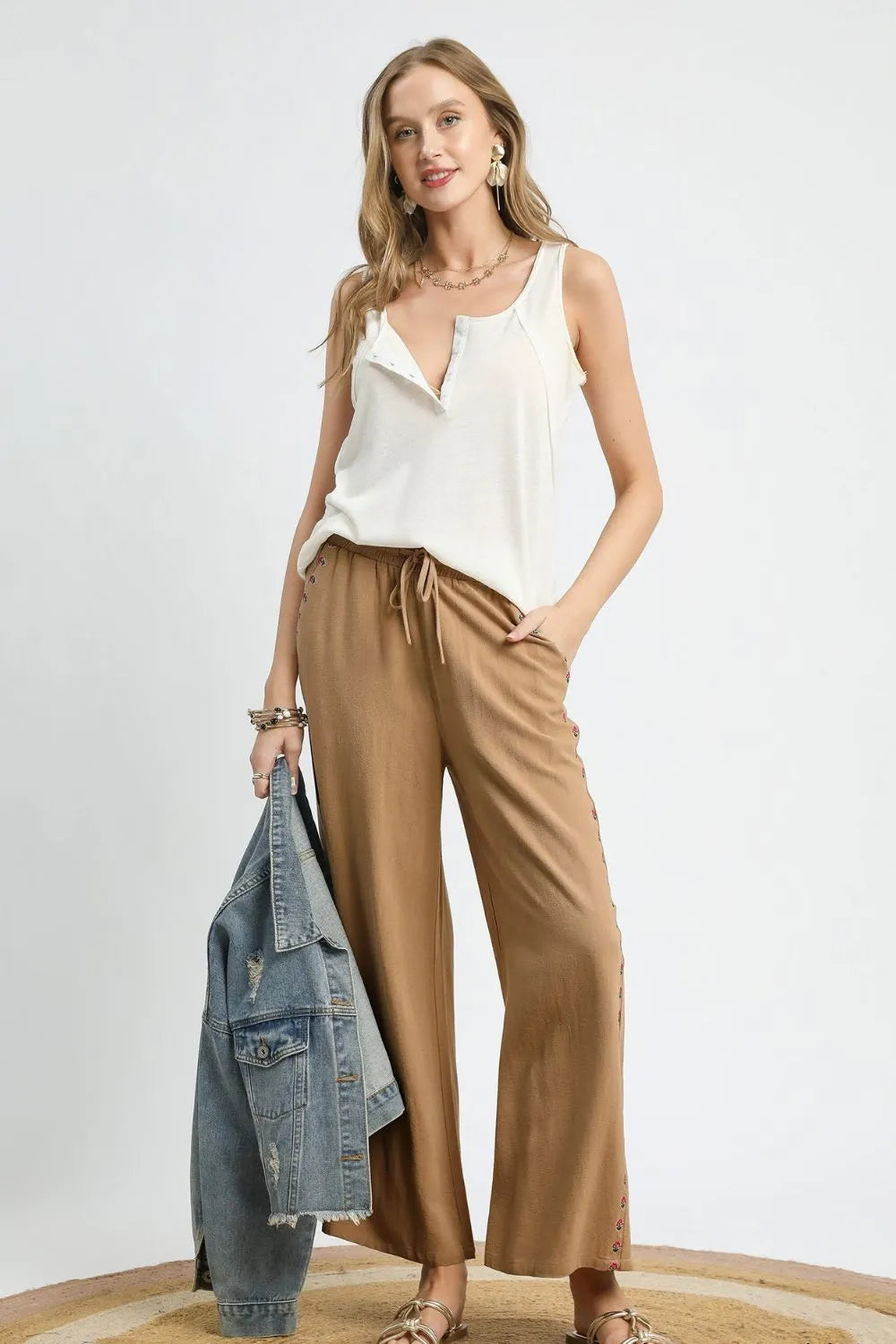 Wide leg drawstring pants with pockets and decorative trim.