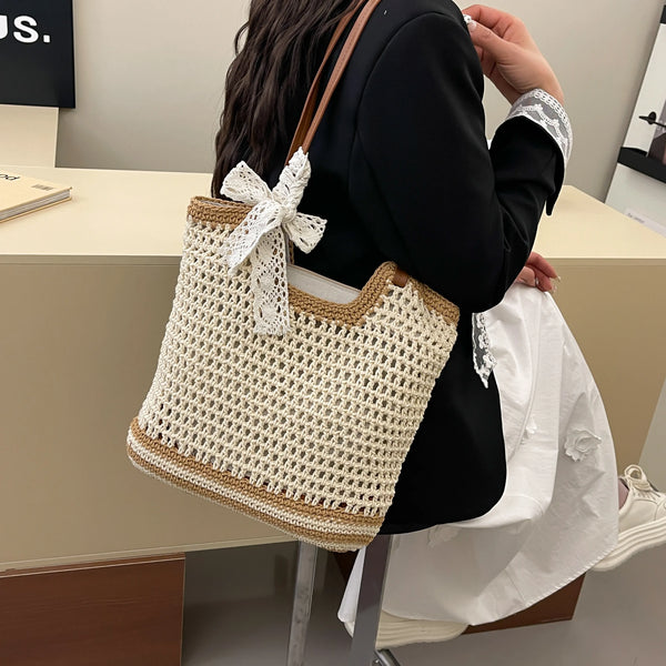Medium polyester woven straw tote bag with bow detail.