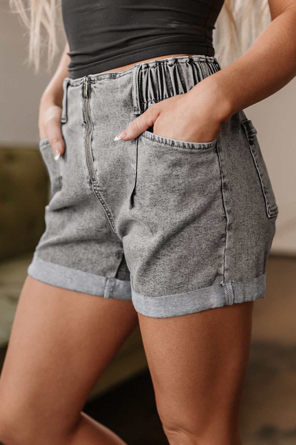 Distressed raw hem denim shorts with buttons and pockets.