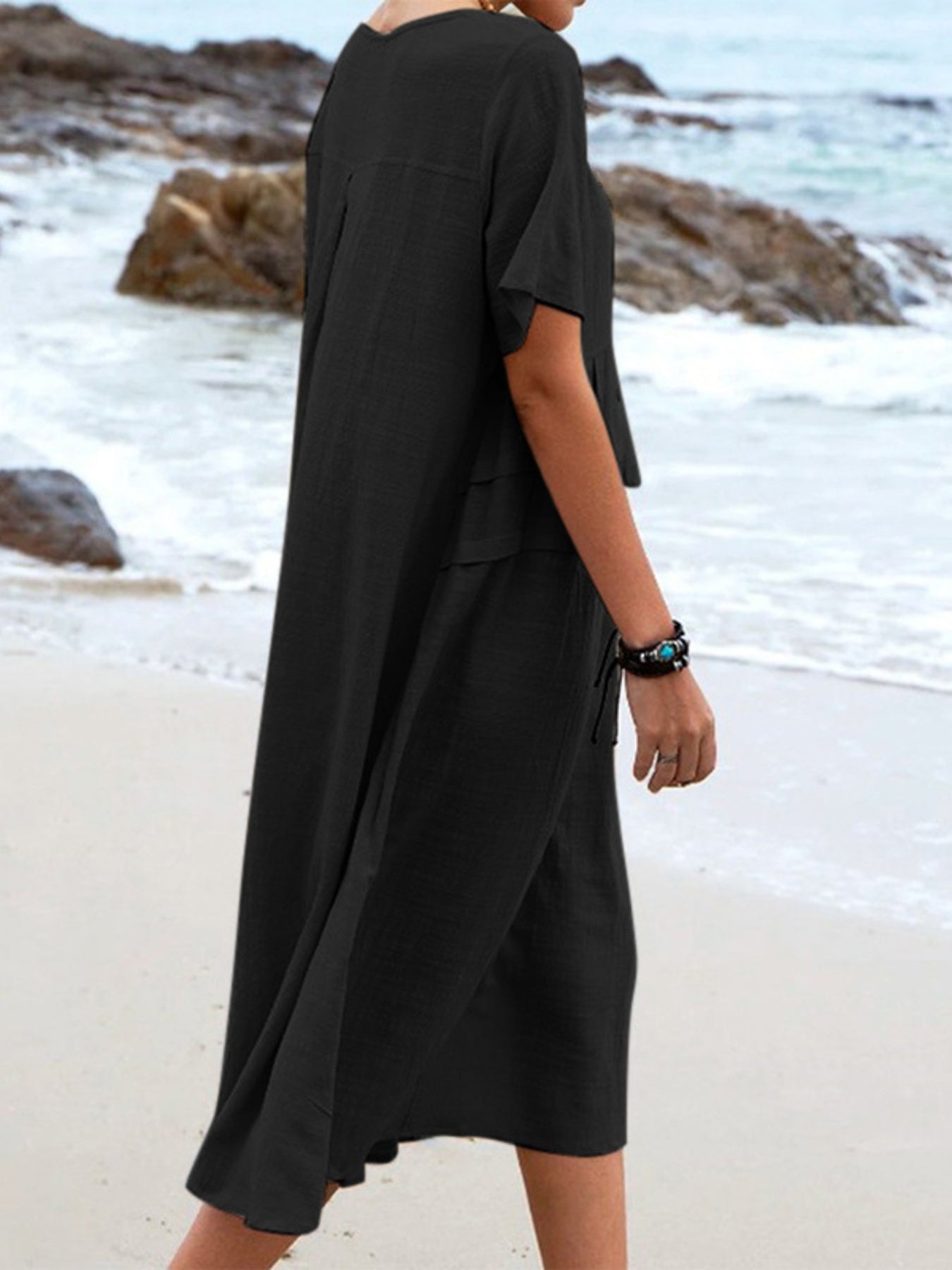 Plus size loose midi dress with short sleeves and pockets shown in cream and black by the beach