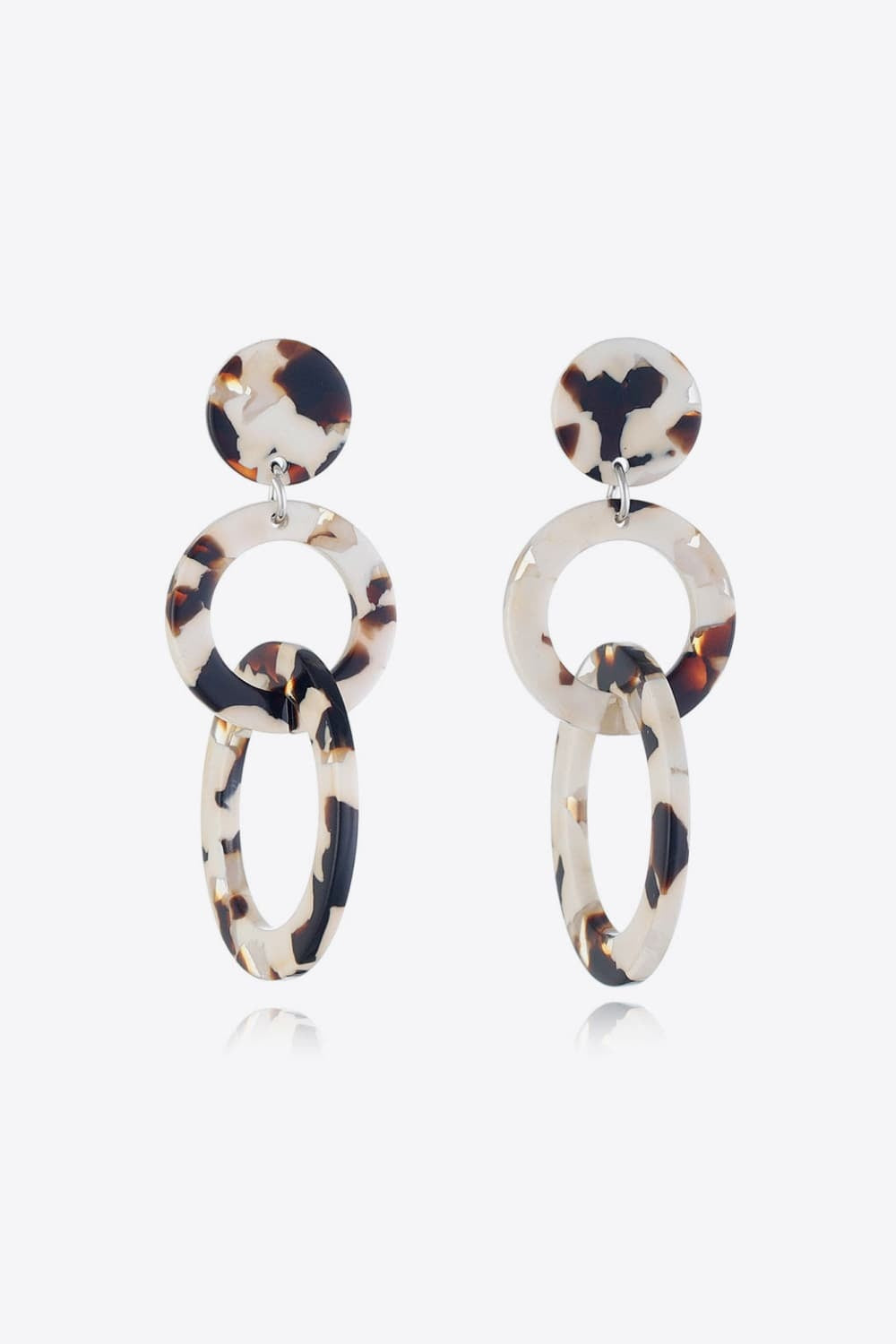 Acrylic double-hoop earrings feature layered oval and round hoops in a cream, brown, and black tortoiseshell pattern with polished sculptural construction.