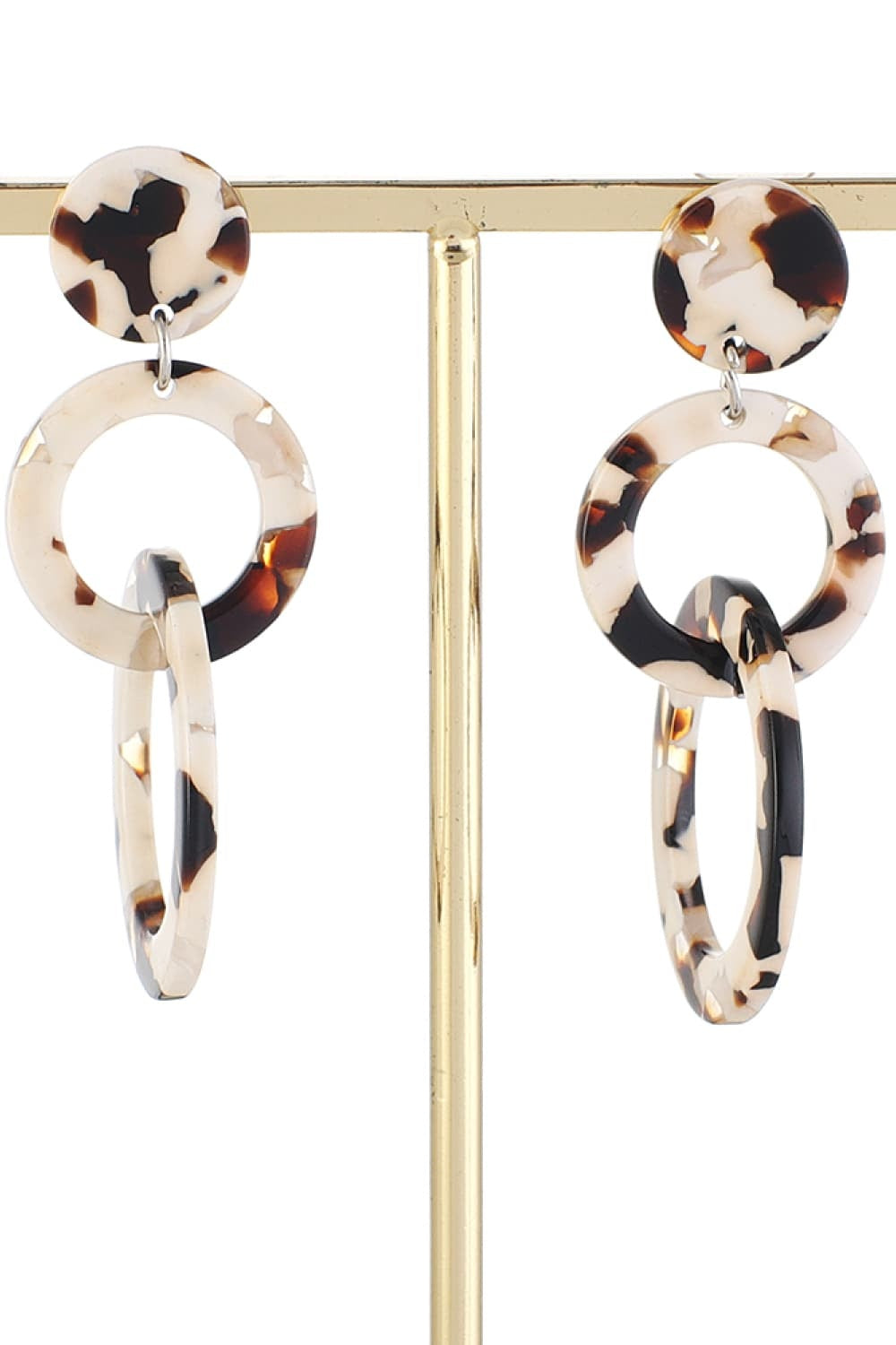 Acrylic double-hoop earrings feature cream, brown, and black tortoiseshell-style oval hoops layered beneath round marbled studs for a sculptural statement silhouette.