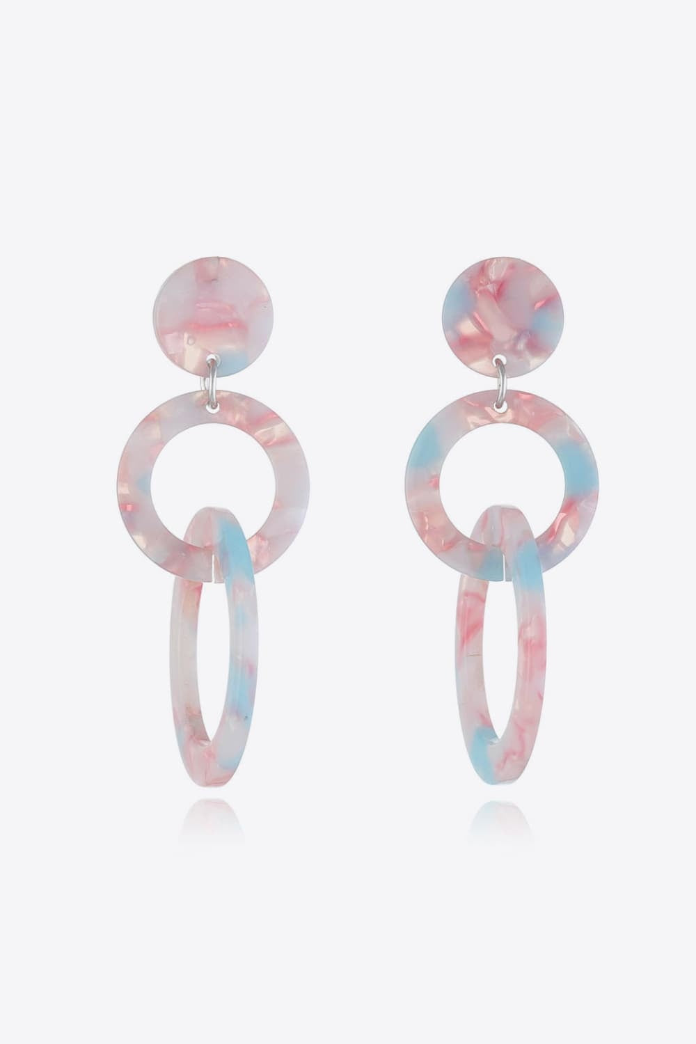 Acrylic double-hoop earrings feature translucent pink-and-blue marbling, round studs, and linked circular and elongated hoops for a sculptural statement silhouette.