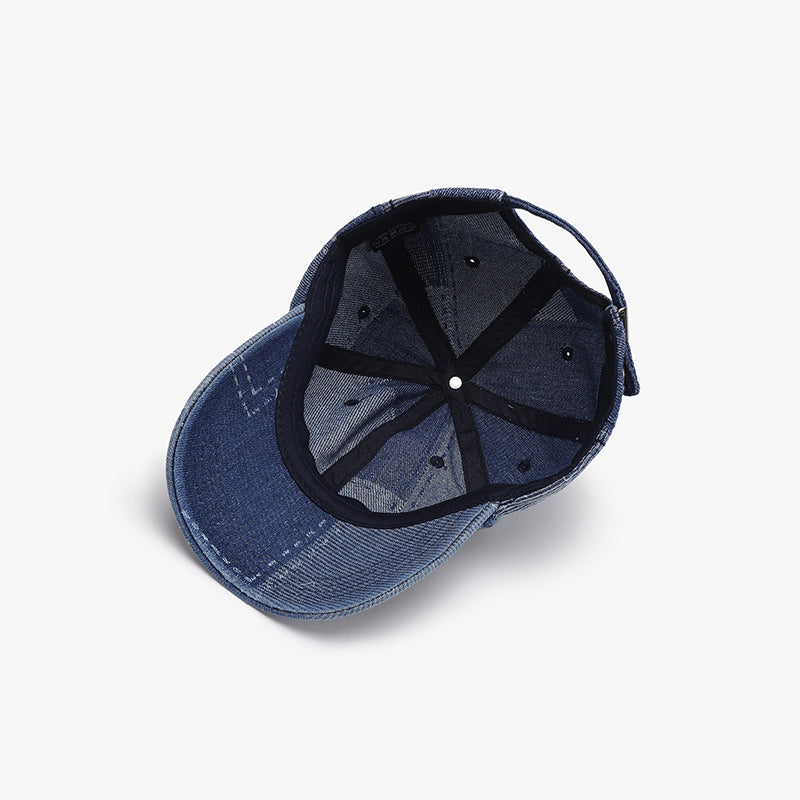 Navy cotton baseball cap shown from below, featuring a structured six-panel crown, curved brim, ventilation eyelets, and an adjustable back strap.