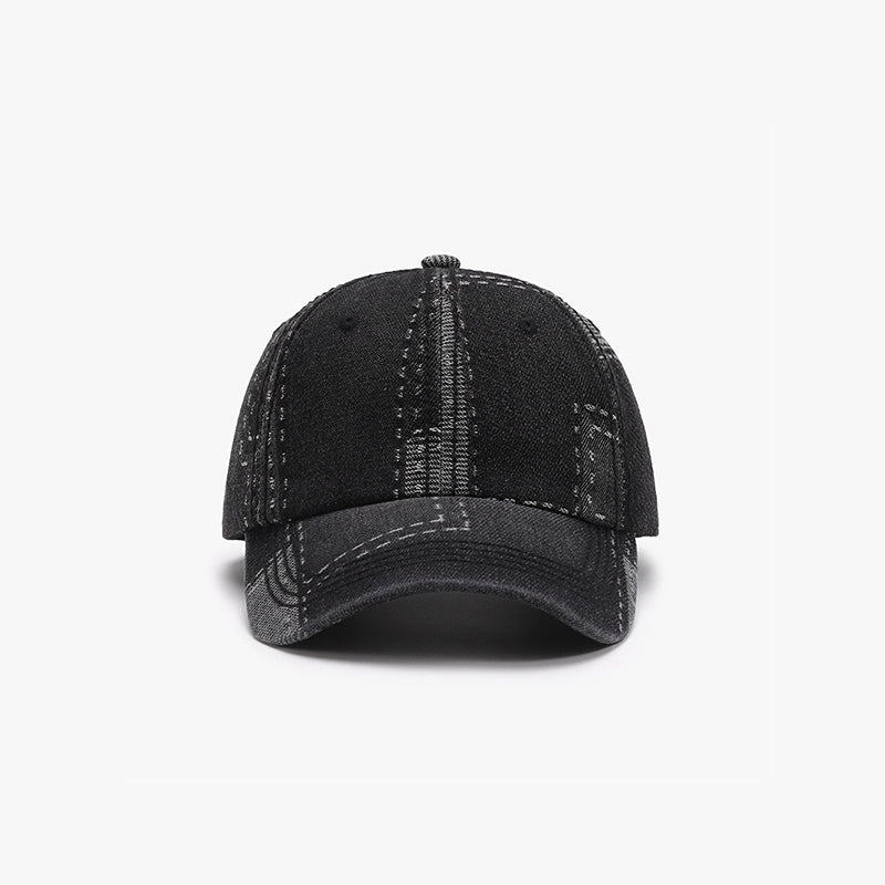A black cotton baseball cap features a structured six-panel crown, stitched seam detailing, ventilation eyelets, and a curved brim for a classic sporty silhouette.