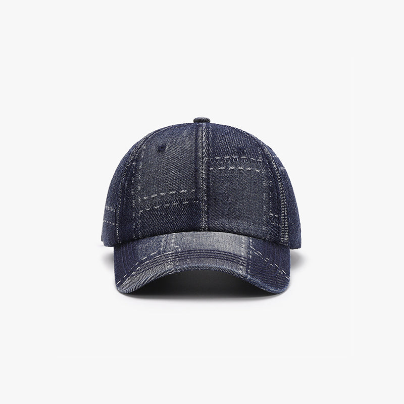 A navy cotton baseball cap with a structured six-panel crown, curved brim, visible seam stitching, and ventilation eyelets.