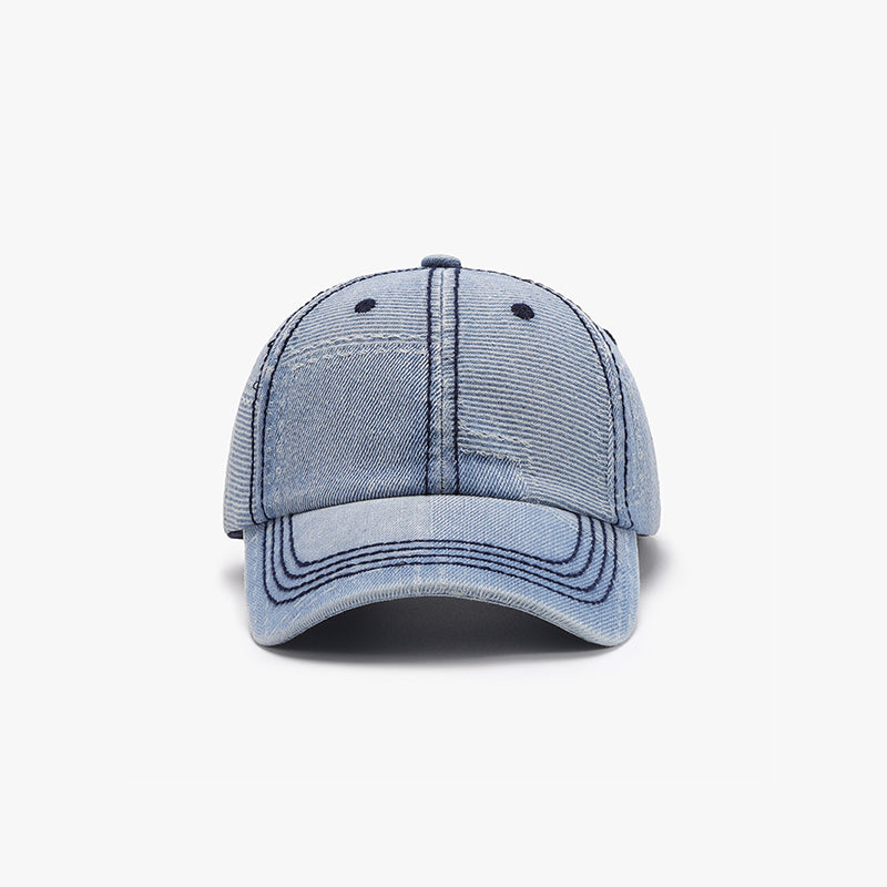 Light blue cotton baseball cap with a structured six-panel crown, curved brim, visible seam detailing, and ventilation eyelets.