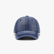 Blue cotton baseball cap shown front-facing with a structured six-panel crown, curved brim, visible seam detailing, and ventilation eyelets.