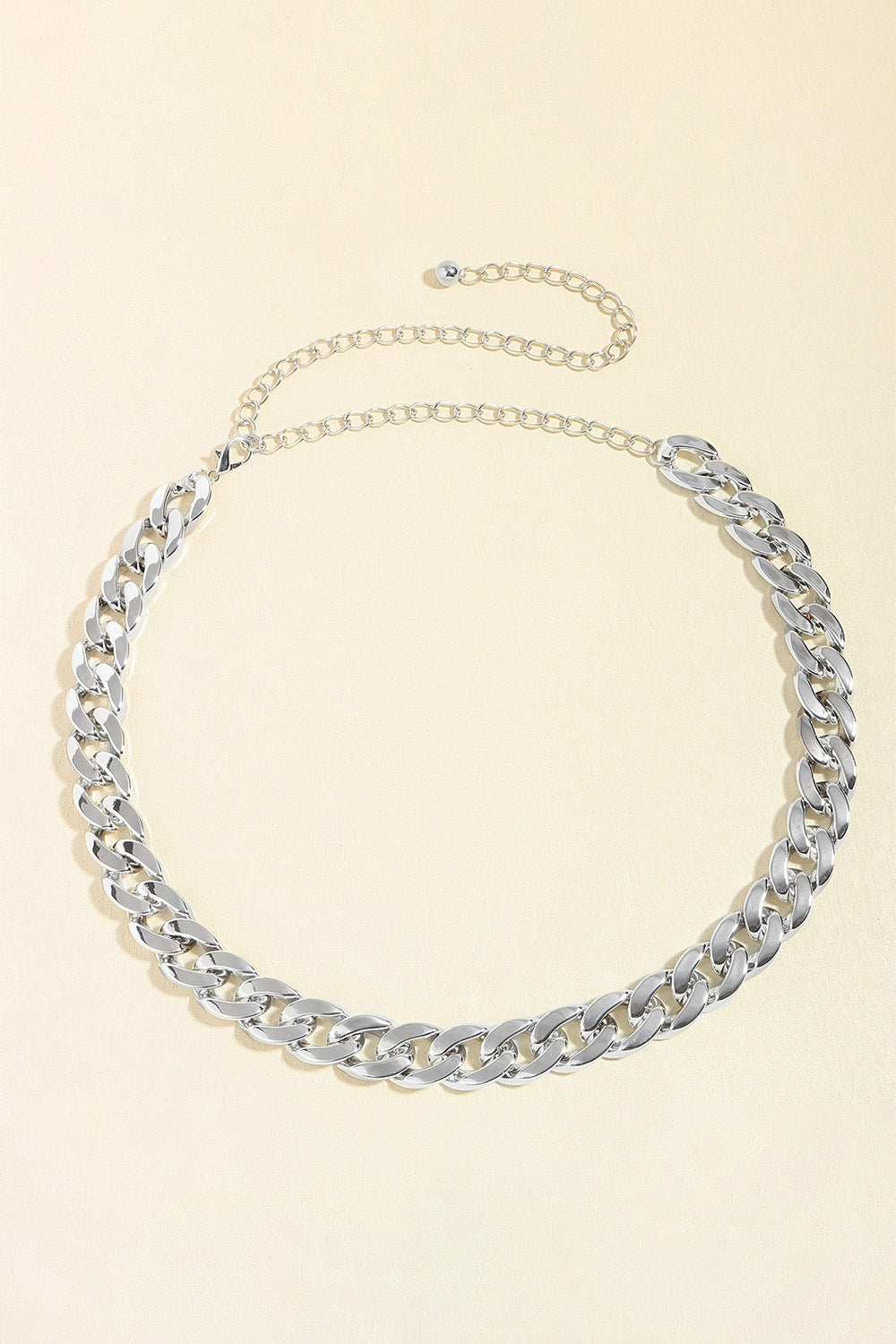 Silver-tone adjustable curb chain belt featuring bold interlocking links and a slender extension chain for versatile wear at the waist or hips.