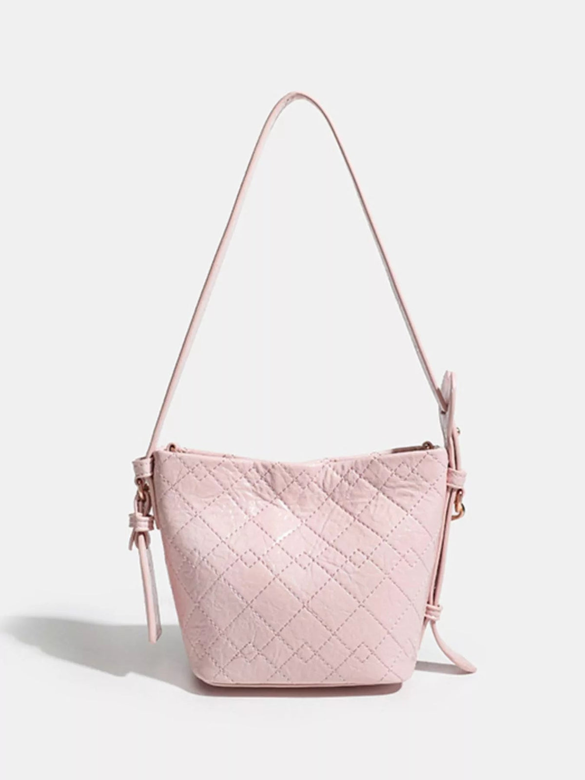 Small pink PU leather bucket bag with diamond quilting, a tapered silhouette, and a long adjustable strap with side hardware.