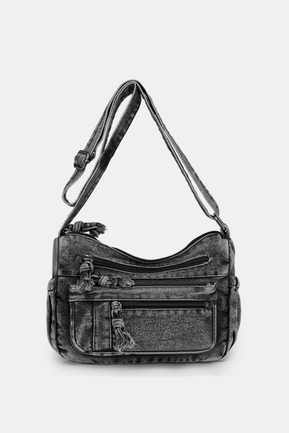 Dark denim crossbody bag with an adjustable strap, softly curved top line, medium silhouette, multiple zippered compartments, and front pockets.
