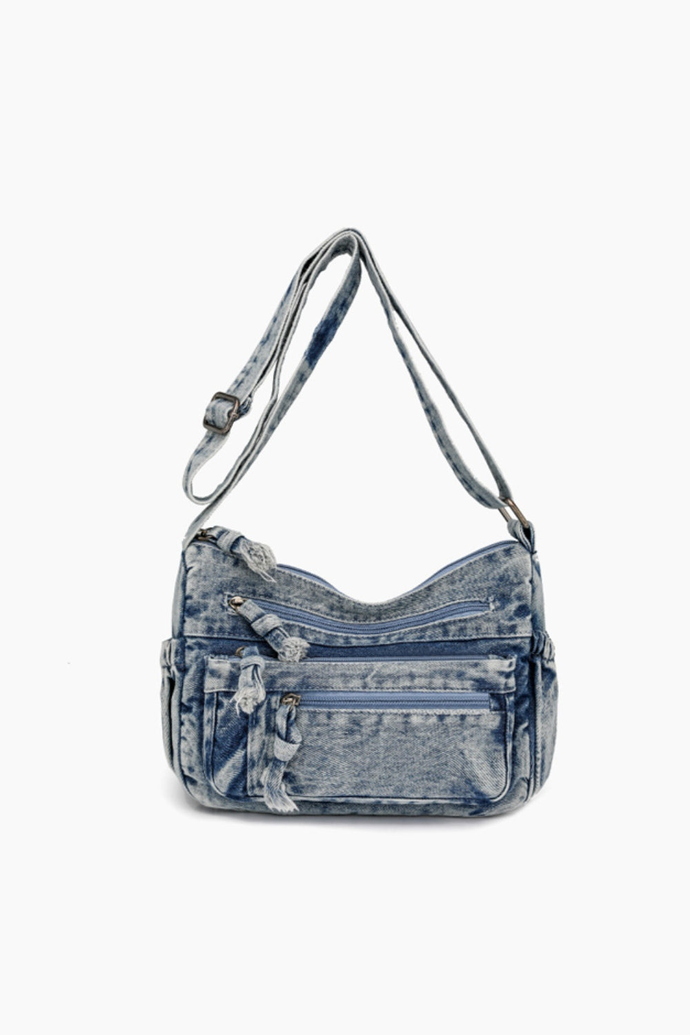 Light blue denim crossbody bag with an adjustable strap, softly curved silhouette, multiple zippered compartments, and practical front pockets.