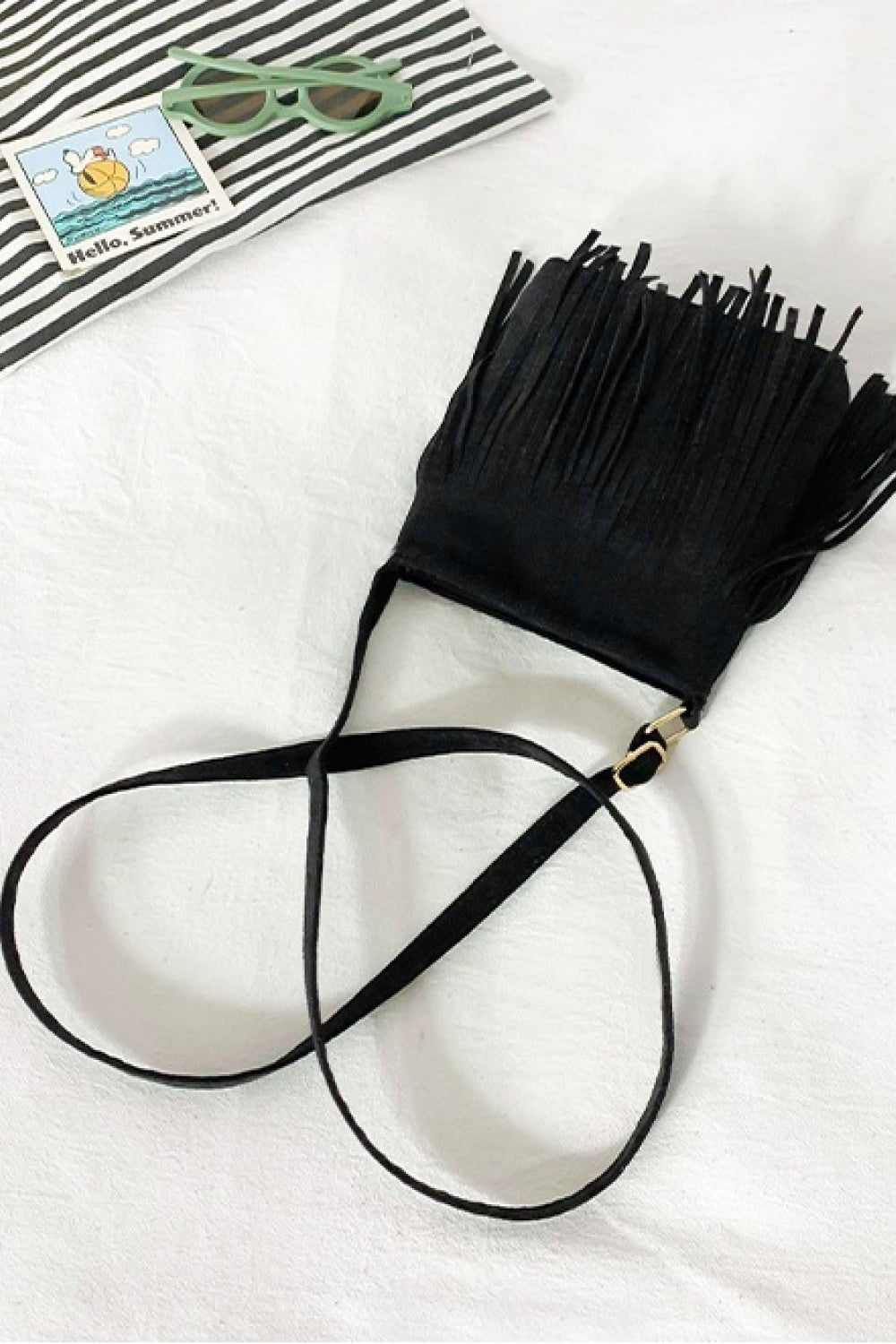 Black PU leather crossbody sling bag with a compact rectangular silhouette, long fringe detailing, and a slender strap with gold-tone hardware.