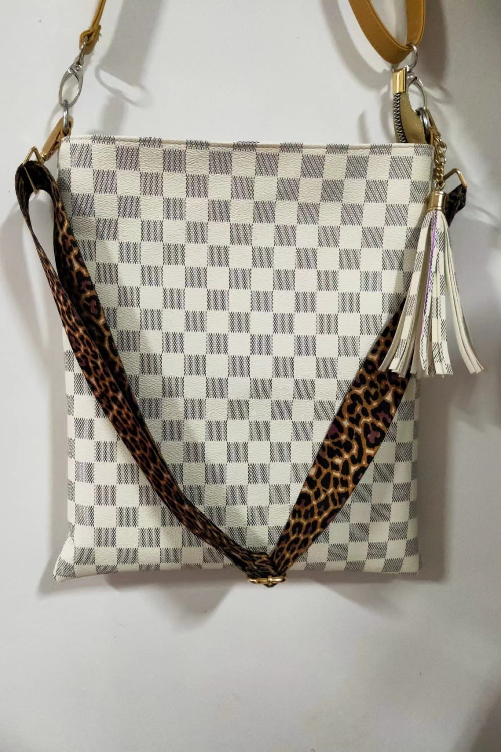Large PU leather shoulder bag with a white and gray plaid silhouette, leopard-print strap, gold-tone hardware, and a contrasting tassel accent.