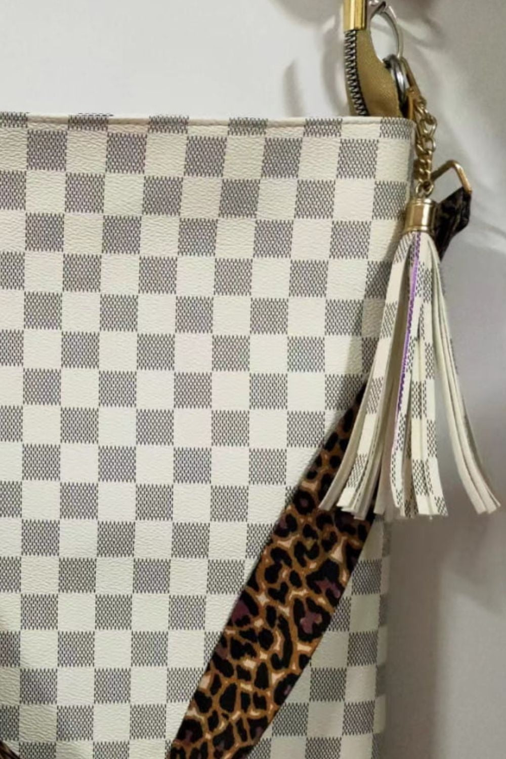 Large white and gray checked PU leather shoulder bag with a leopard-print strap, gold hardware, and a long tassel detail.
