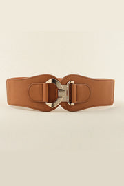 Broad brown PU and elastic belt with curved stitched edges and a sculptural alloy buckle, creating a polished, waist-defining accessory.