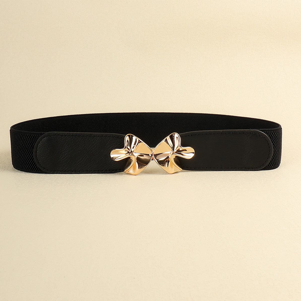 Black PU elastic belt with a wide streamlined silhouette, stitched end panels, and a sculptural polished gold alloy buckle shaped like a bow.