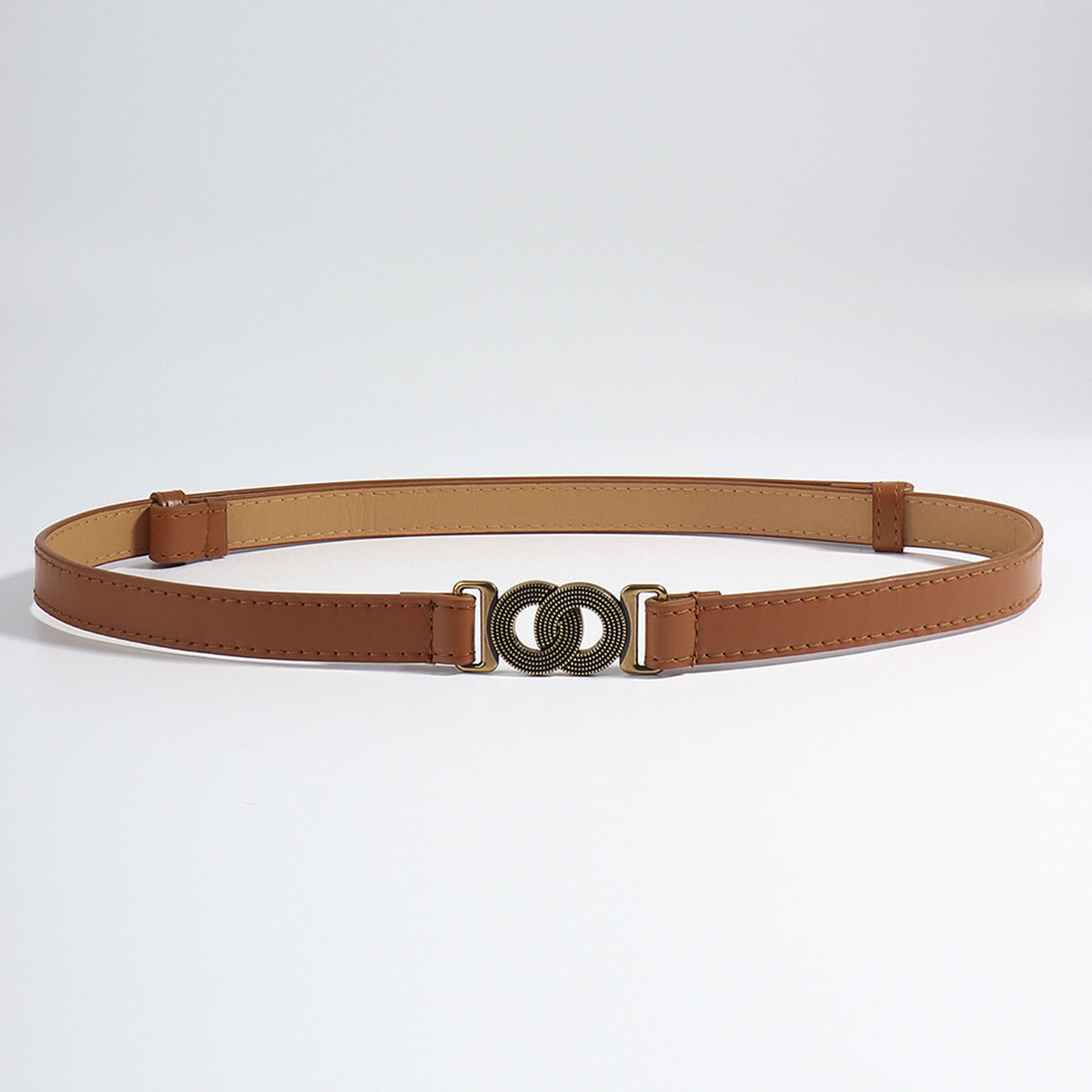 Slim brown PU belt with clean stitched edging and an eye-catching alloy buckle featuring an interlocking circular motif.