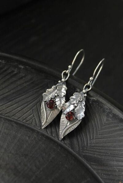 Silver-tone alloy leaf-shaped drop earrings feature textured botanical construction and faceted rhinestone accents for a graceful, nature-inspired finish.