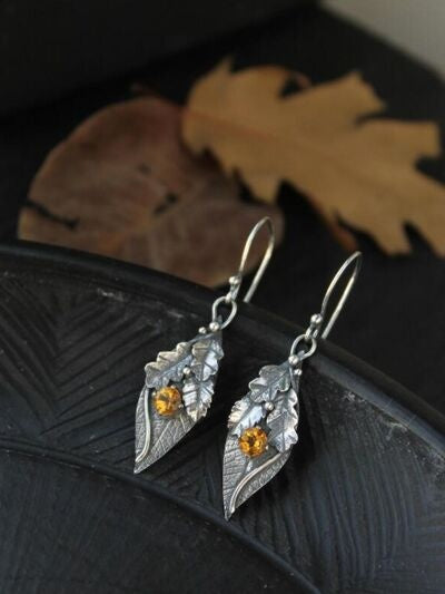 Leaf-shaped alloy drop earrings feature silver-toned botanical detailing and faceted rhinestones with warm amber accents for a graceful, sparkling finish.